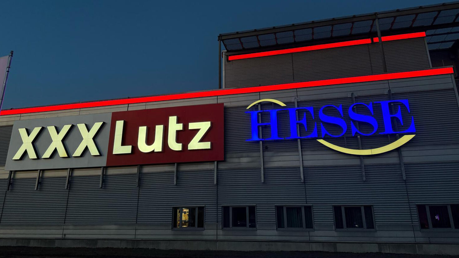 Leuchtschriften bei Nacht an der Fassade des XXXLutz in Garbsen, Deutschland
