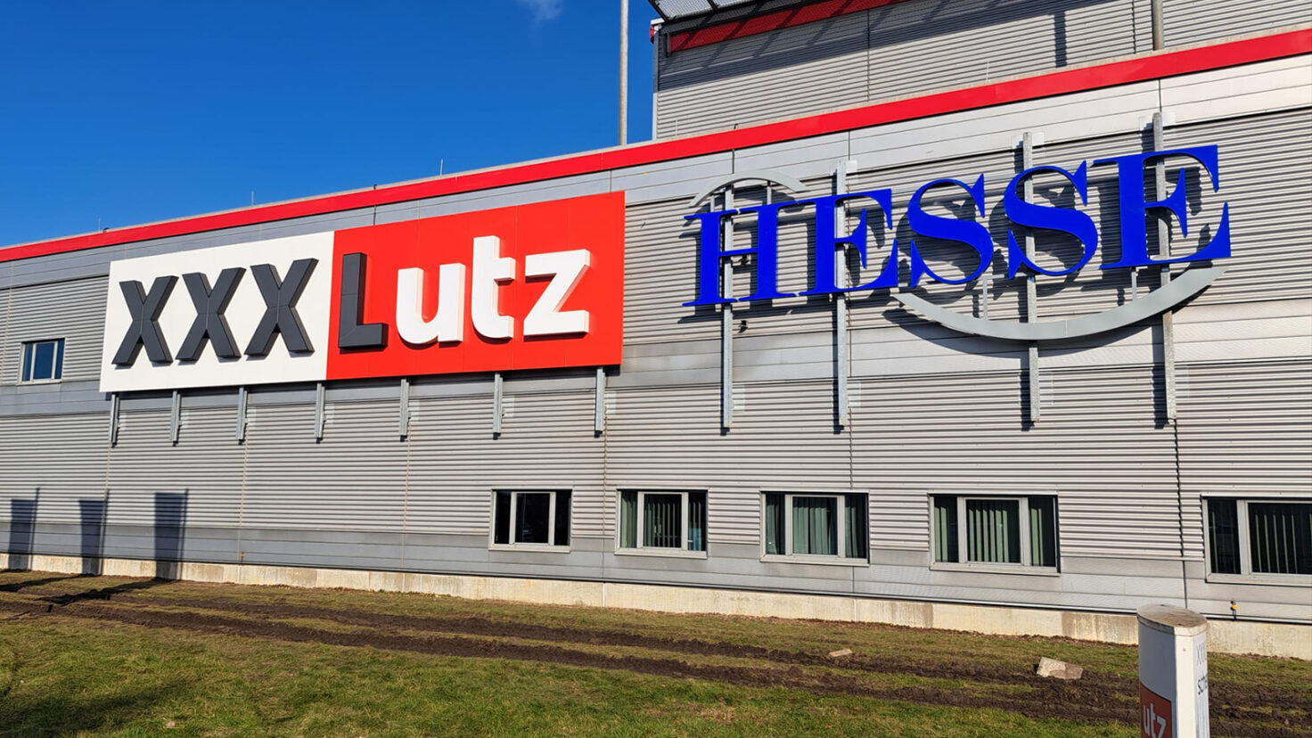 Leuchtschriften bei Tag an der Fassade des XXXLutz in Garbsen, Deutschland