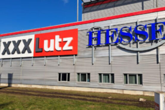 Leuchtschriften bei Tag an der Fassade des XXXLutz in Garbsen, Deutschland