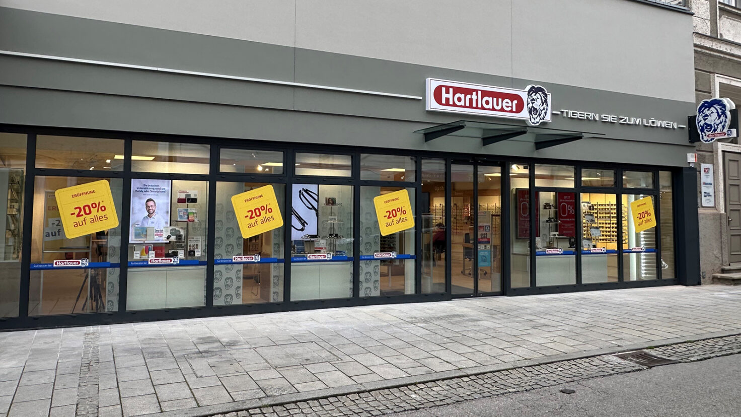 Leuchtschilder und Leuchtschriften an der Fassade der Hartlauer Filiale in Grieskirchen