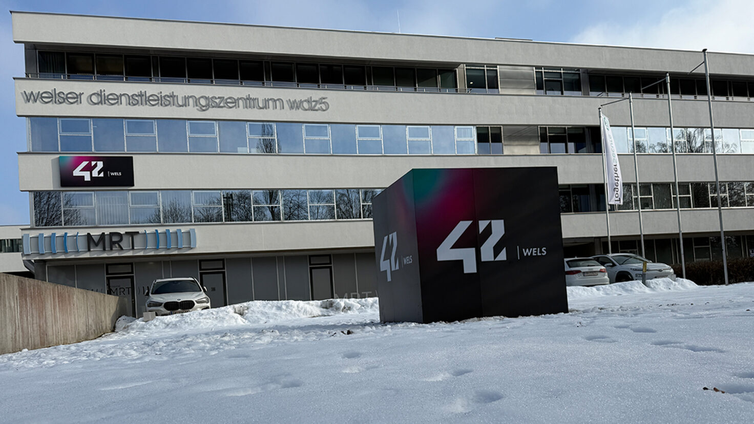 Leuchtender Würfel und Fassaden-Leuchtschild beim Campus 42 in Wels