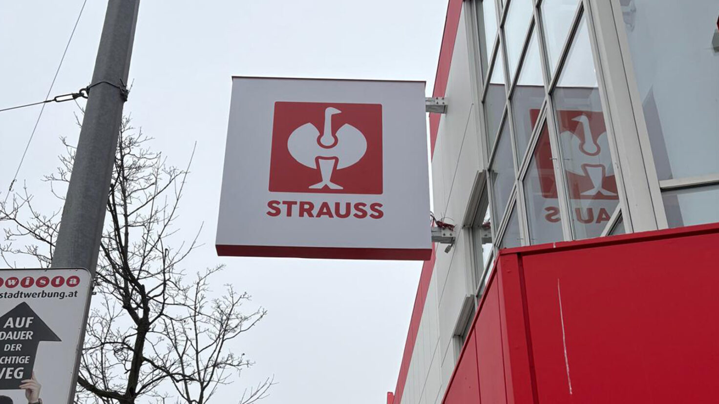 auskragendes Logoschild an der Fassade